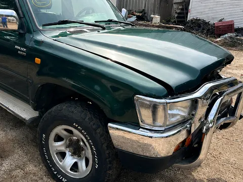 Toyota Hilux SRV verde com quebra-mato cromado no pátio