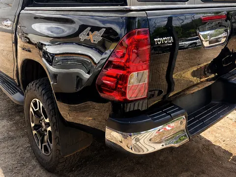 Traseira de uma Toyota Hilux SRV preta com a lanterna e o para-choque cromado