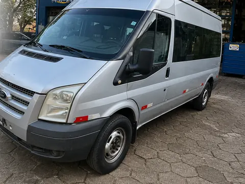 Van Ford Transit prata de passageiros em frente à loja